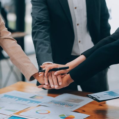 Motivated successful business team giving high five, happy young students employees group join hands with senior teacher mentor, team building unity concept, help support in teamwork, close up view